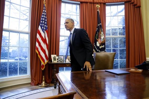 President Barack Obama gets up from his desk after signing the memorandum