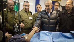  Israeli Prime Minister Benjamin Netanyahu shaking hands with a militant in an Israeli field hospital in Syria’s occupied Golan Heights.