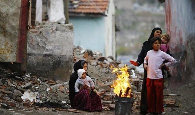 Syrian refugees warm themselves around a fire in Hacibayram district of Ankara