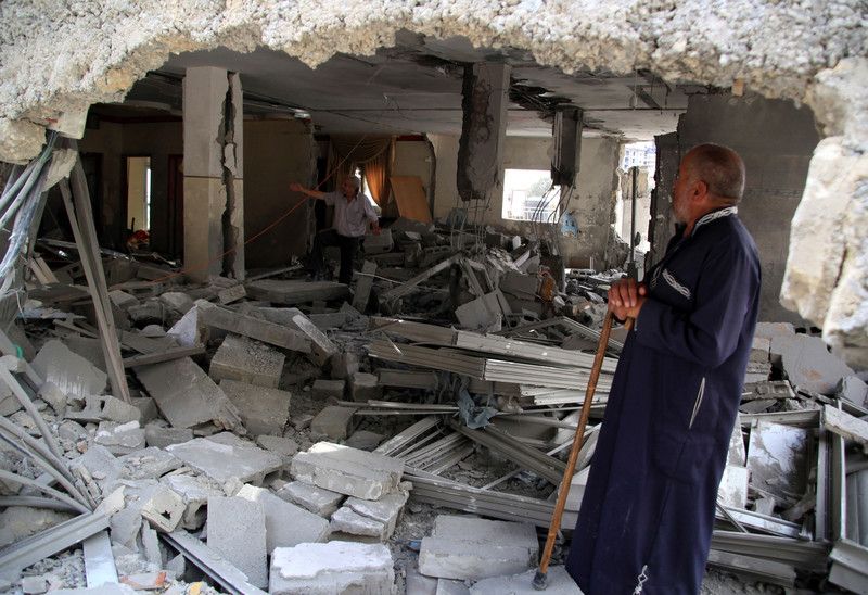 An old Palestinian man surveys his house after it got punitively demolished