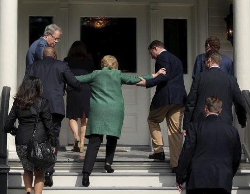 Hillary Clinton being helped up the stairs