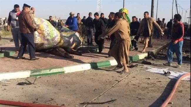 People carry away the bodies of victims from the site of a bomb attack near Hilla, Iraq, November 24, 2016.