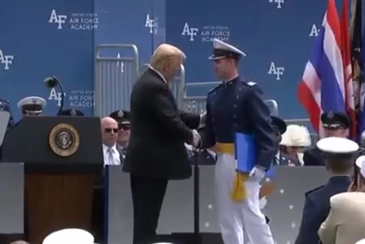 President Trump stands, salutes and shakes hands with 900 cadets