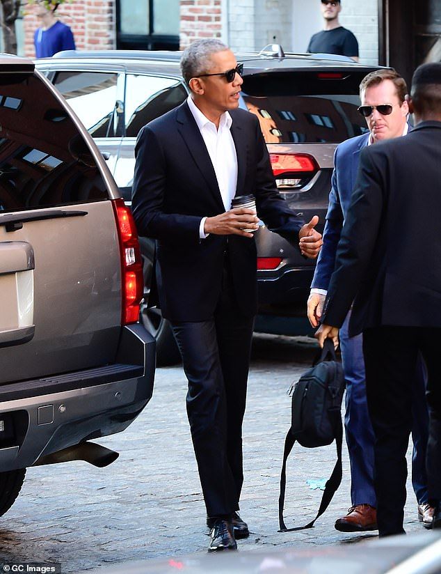 The former US president was caught in Manhattan wearing a black suit and sunglasses while holding a takeaway coffee on his way to meet Robert De Niro