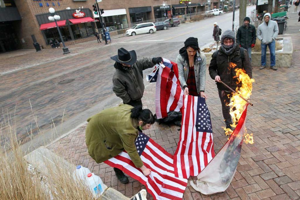 Leftists burns American flags on the pedestrian mall along Clinton Street in Iowa City, Iowa, on Thursday, Jan. 26, 2017.